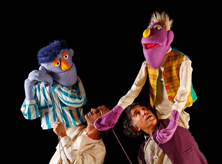 Two puppeteers holding their puppets at the Center for Puppetry Arts.