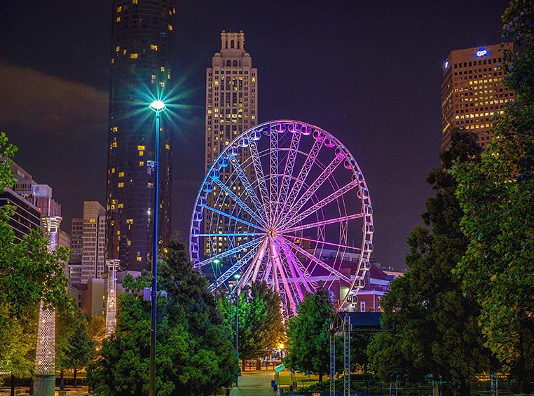 A 20-story Ferris wheel lit up at night in Centennial Park in Atlanta, GA. 