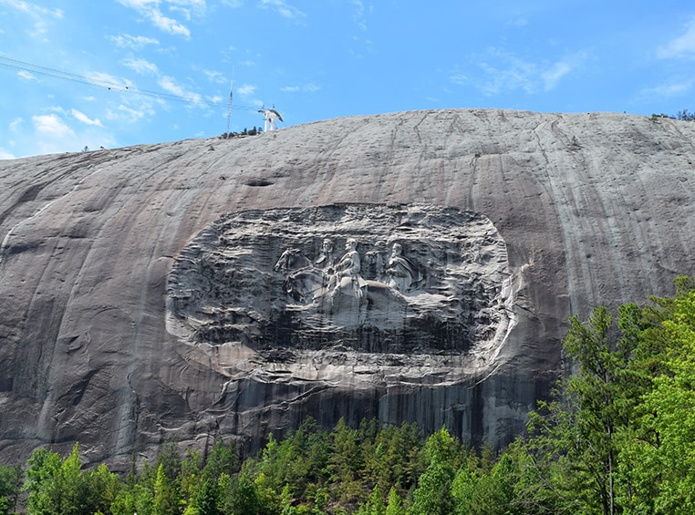 A smooth gray mountain with a carving on the side.