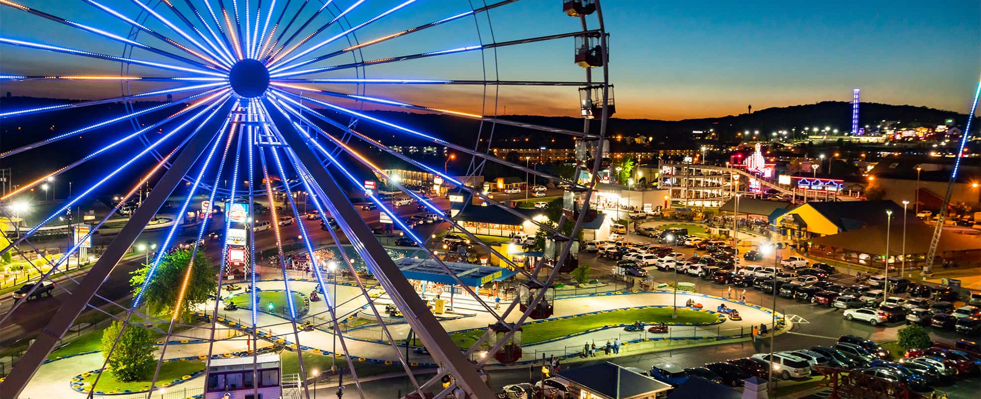 A ferris wheel with the city of Branson, Missouri lit up in the distance.