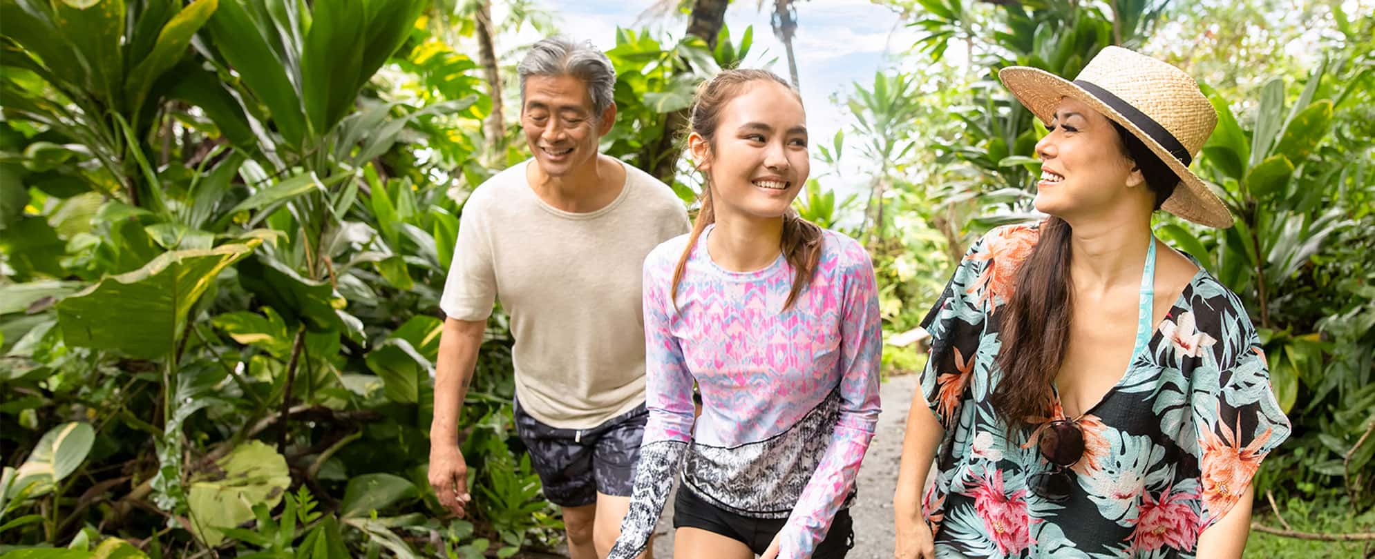 A mom, dad, and daughter hike through the jungle in Kailua-Kona on the Big Island, Hawaii,