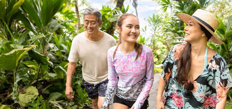 A mom, dad, and daughter hike through the jungle in Kailua-Kona on the Big Island, Hawaii,