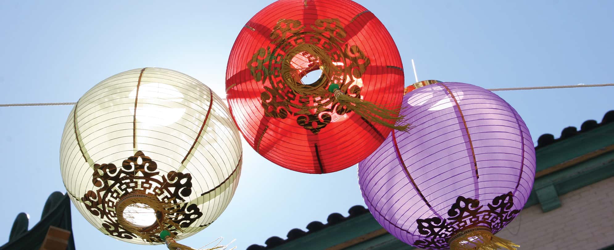 Three paper festival lanterns hanging from a wire in China Town of San Francisco, California. 