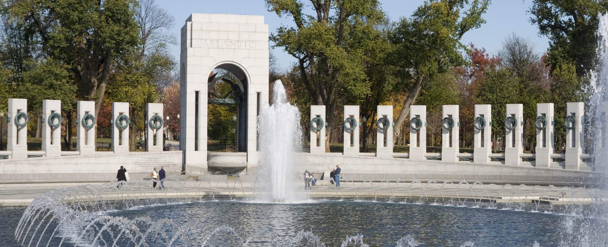 People walking around the fountain at the World War II memorial in the National Mall in Washington, D.C.