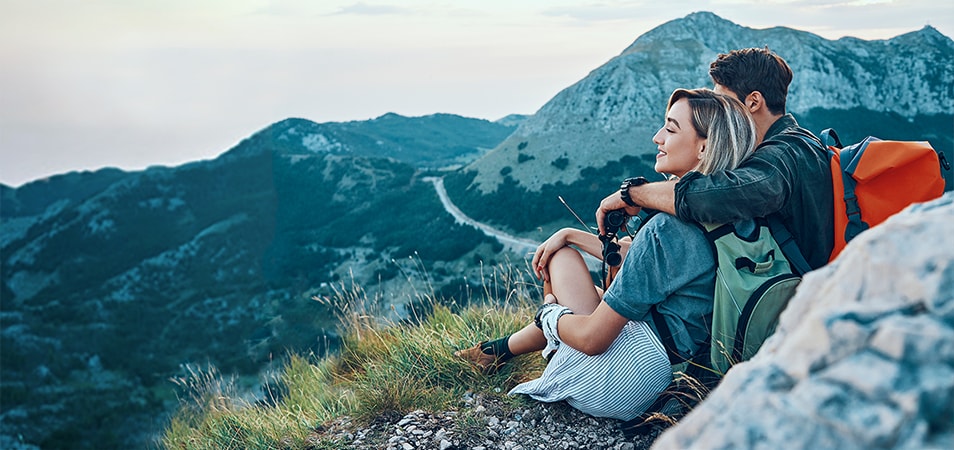 Young hiking couple looking out over mountains with Club Wyndham Travel Services.