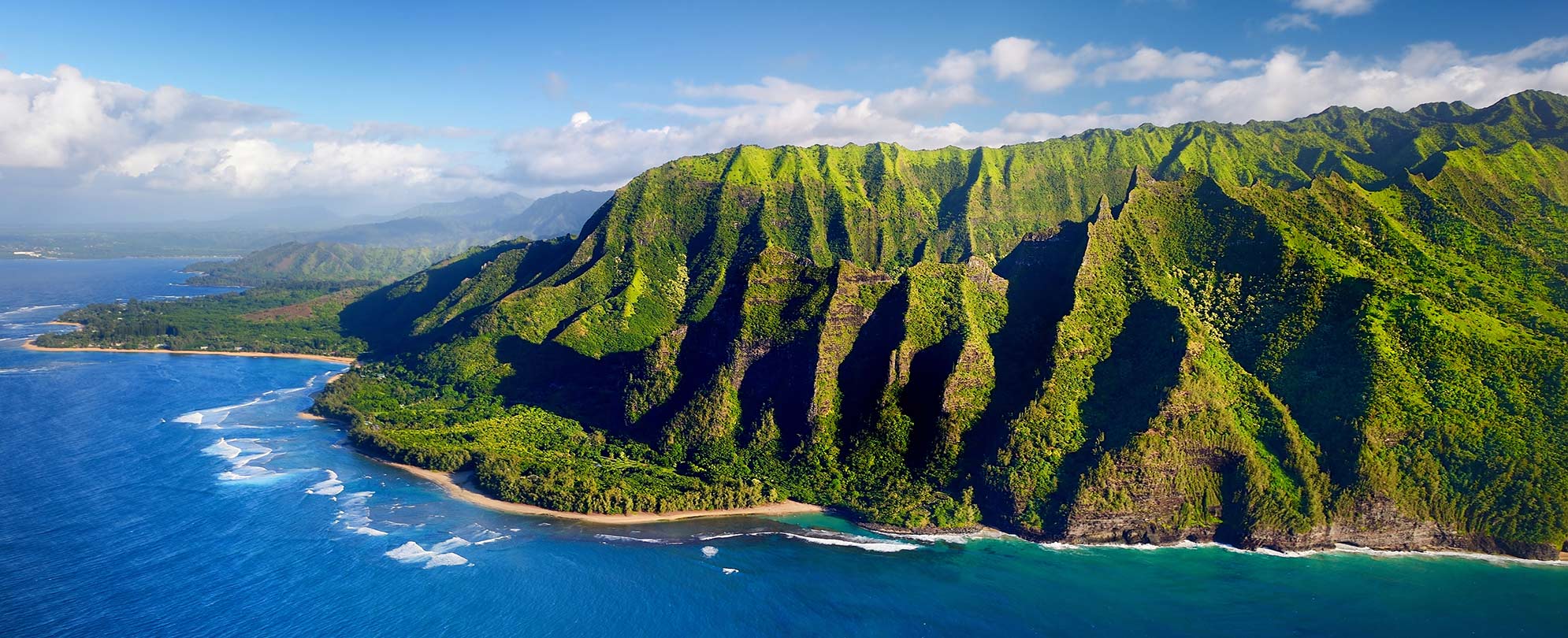 Sparkling water and a lush mountain range in Hawaii with Club Wyndham.