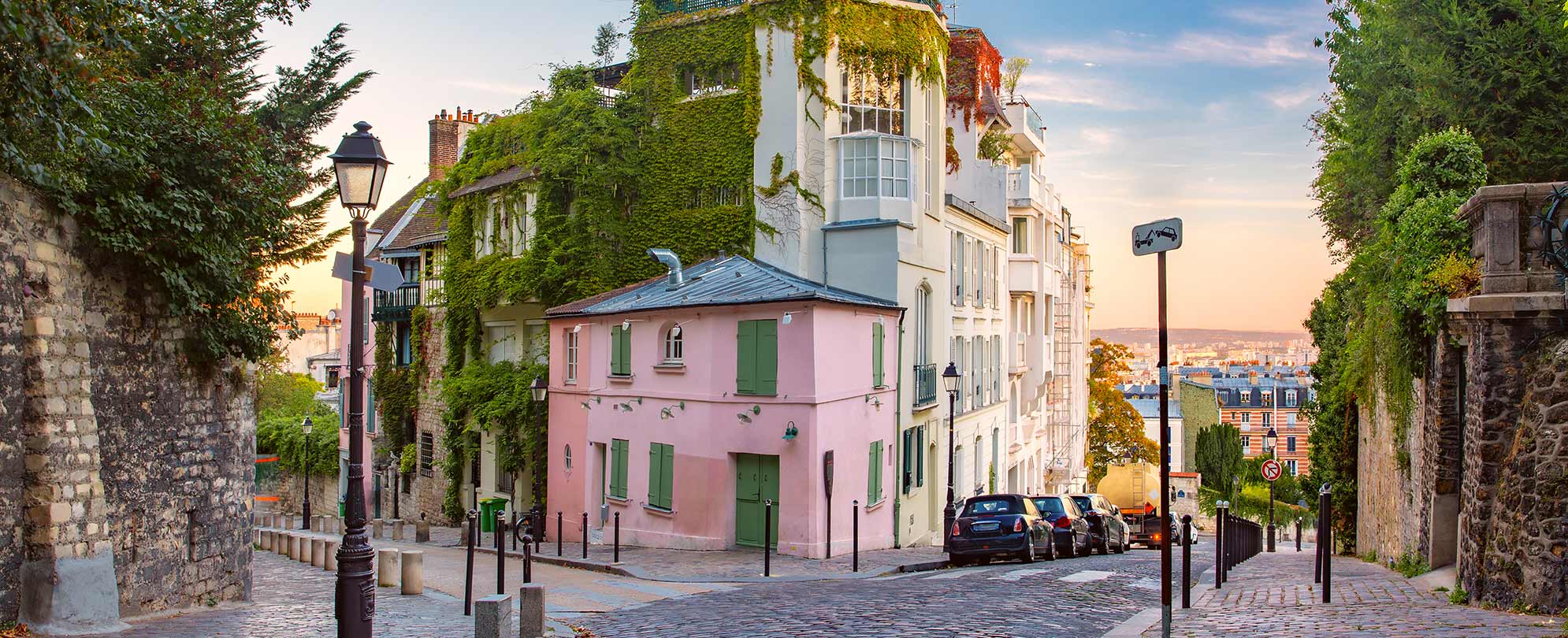 Cozy old street with pink house at the sunny sunrise quarter montmartre in paris france, a stop on a paris Normandy cruise.