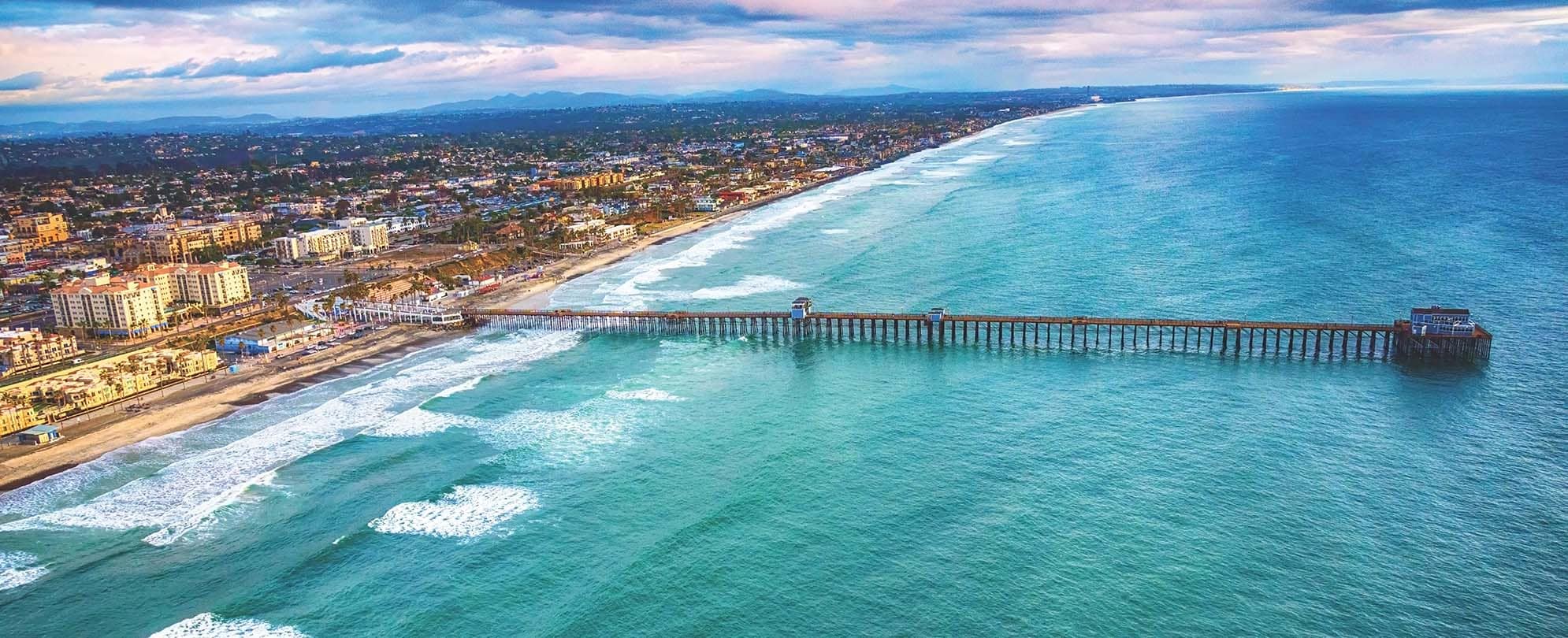 A bird's-eye-view of the Oceanside, California coastline and the Oceanside pier..