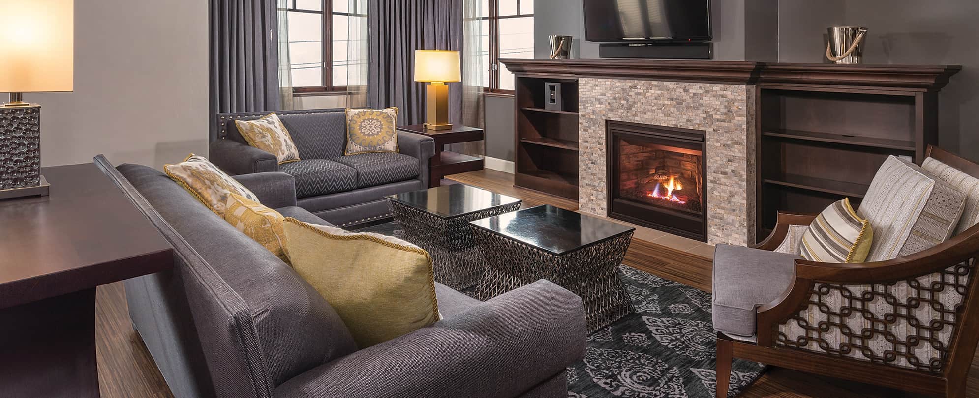 Couches and a glass-top tables in front of a burning fireplace at Club Wyndham Park City, a timeshare resort in Utah.