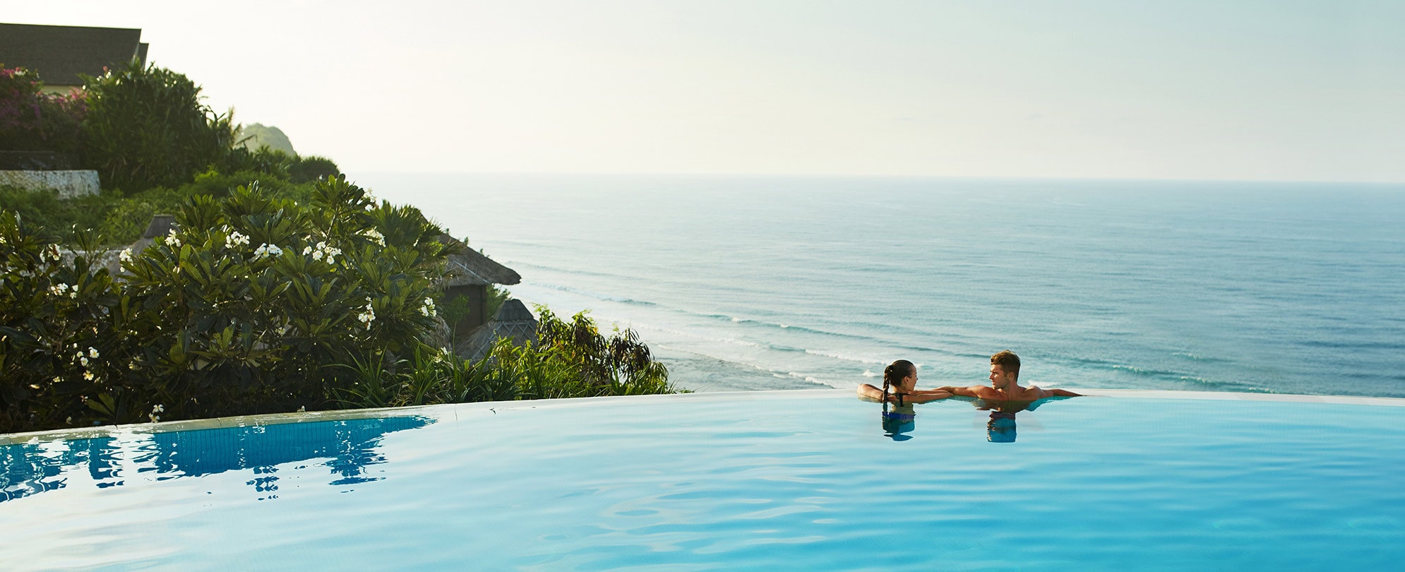 Couple on edge of infinity pool overlooking ocean on their Club Wyndham vacation.