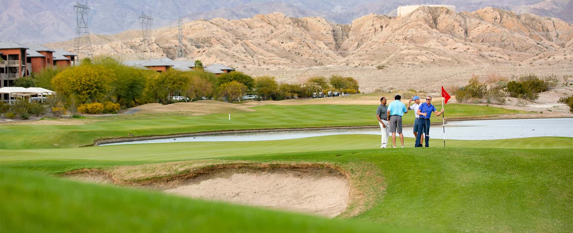 Four men chat on the golf course as they take the flag out of the hole at a Club Wyndham resort