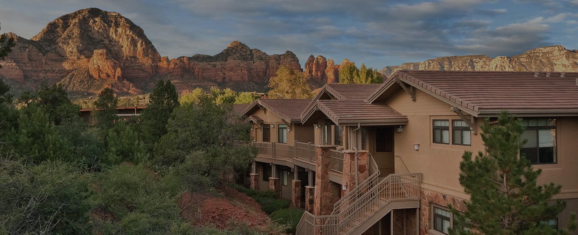 The exterior of Club Wyndham Sedona, a timeshare resort in Sedona, AZ, with red rock mountains in the distance