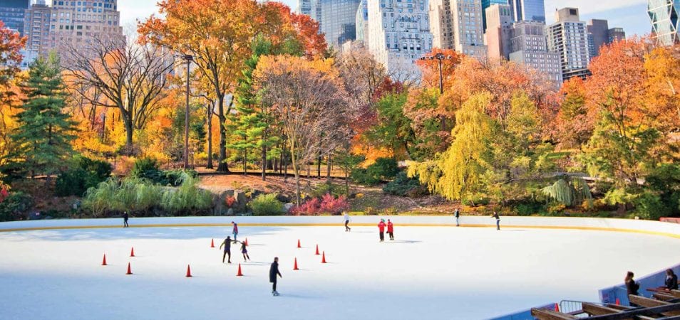 People ice skate on an outdoor skating rink in New York City during the fall