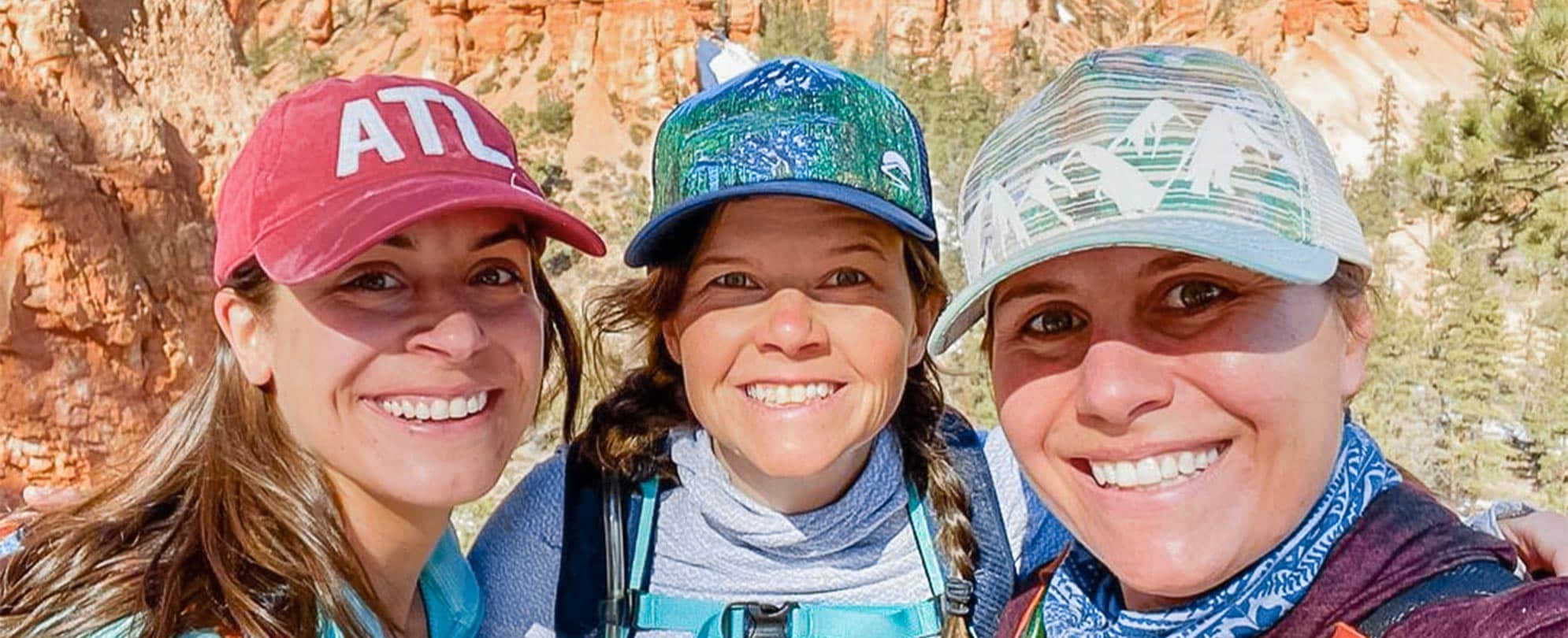 Three woman snap a selfie from inside the Bryce Canyon Amphitheater during a hike through Bryce Canyon National Park in Utah