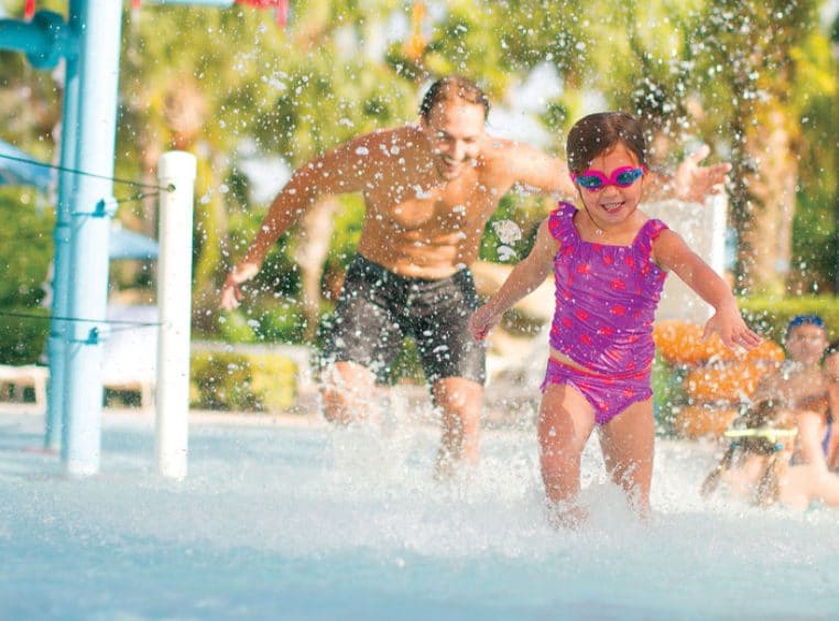 Family on vacation playing at a Club Wyndham Resort pool.