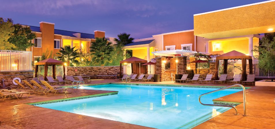 The outdoor pool of WorldMark Tropicana surrounded by sun loungers and cabanas.