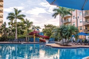 A pool surrounded by chairs and palm trees at WorldMark Palm-Air.