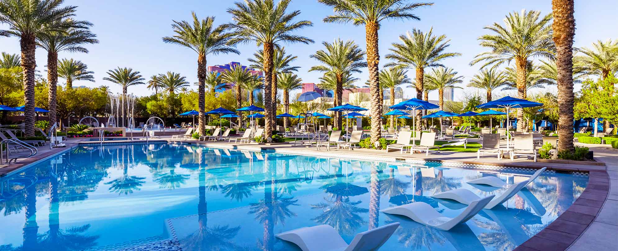 Large pool surrounded by palm trees at Margaritaville Vacation Club by Wyndham - Desert Blue in Las Vegas, NV.