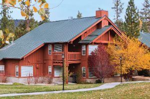 The exterior of WorldMark Big Bear, a cabin-style timeshare resort, surrounded by trees with autumn leaves.