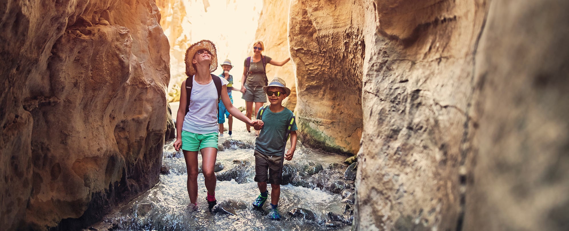 A family of four, hiking through a cave at National Park Moab.